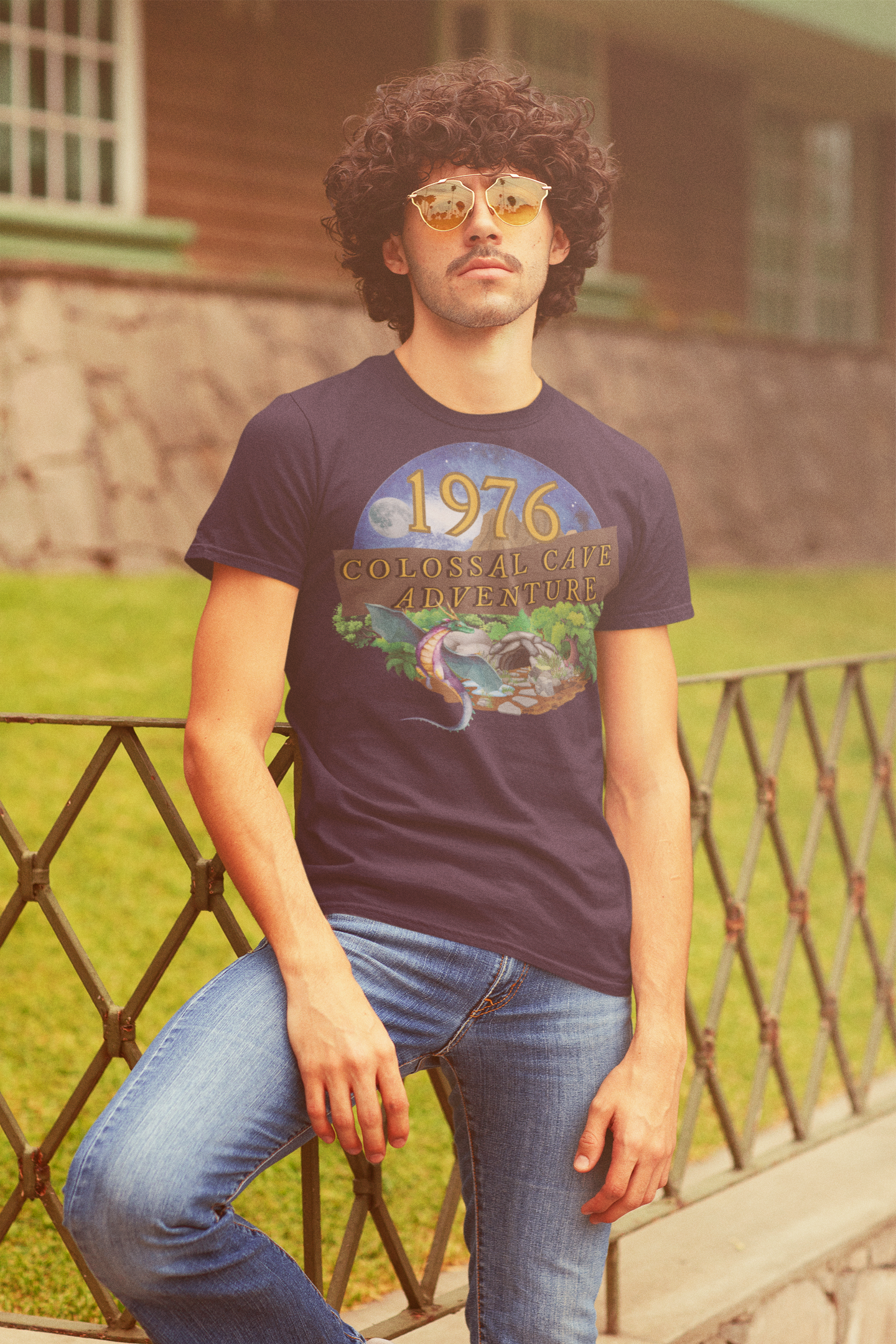 A man wearing a black T-Shirt with words 1976,colossal cave adventure,circular picture of a dragon,cave and woodland,night sky