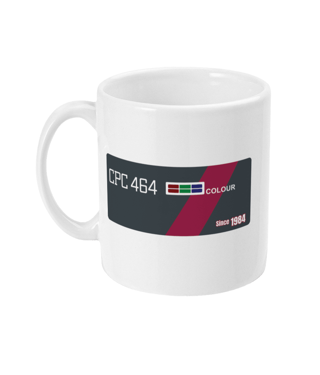 White mug echoing the original Amstrad CPC 464 computer bezel. Features ‘CPC 464’ in bold white text on the left, an RGB color bar, and the word ‘COLOUR’, diagonally across a maroon stripe—mirroring the machine’s iconic styling. A small label on the right reads ‘Since 1984’, celebrating the computer’s launch year and legac
