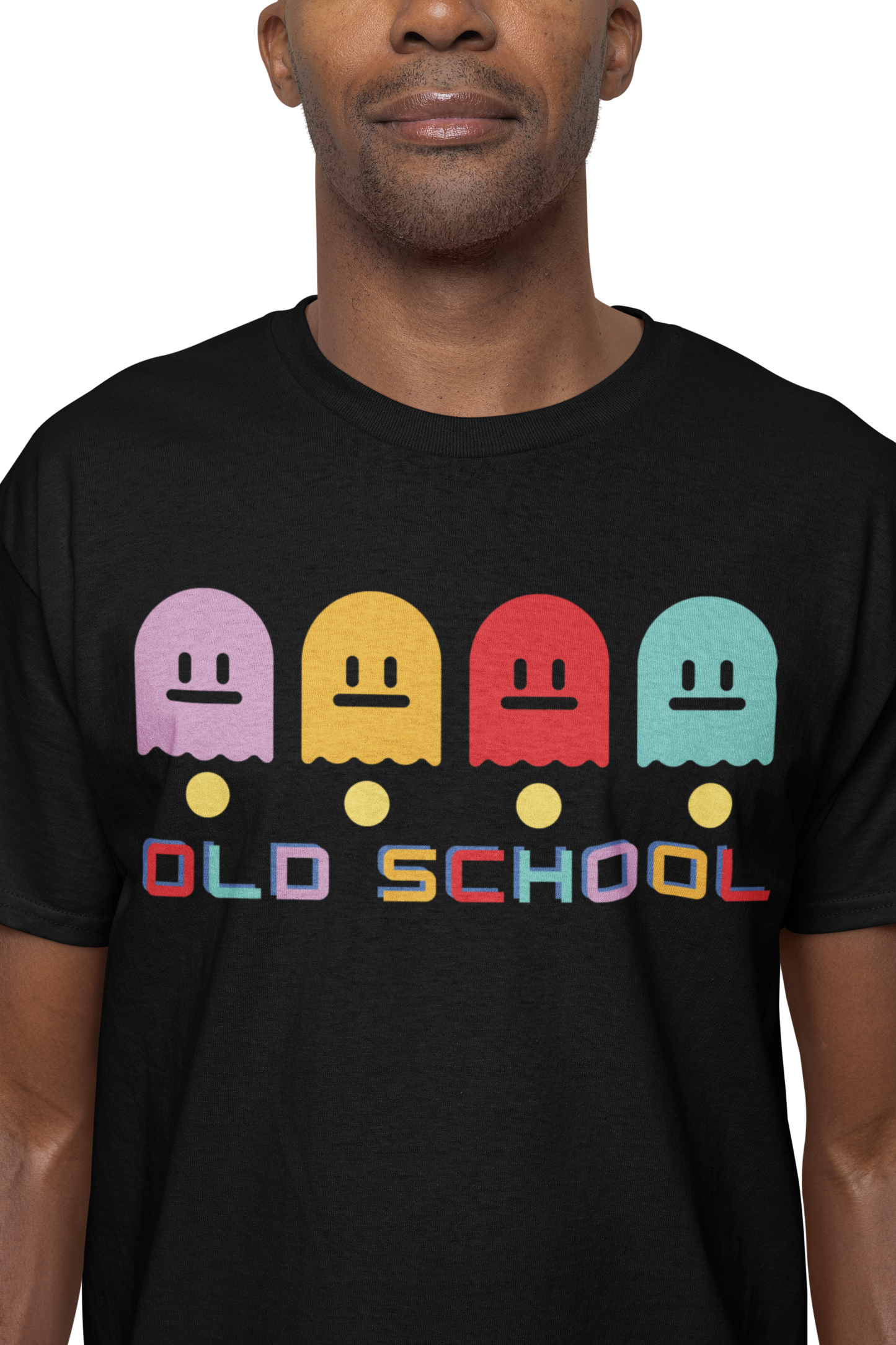 A man wearing a black T-Shirt with multicoloured ghost characters , over yellow pac man dots and old school in different colours for each letter