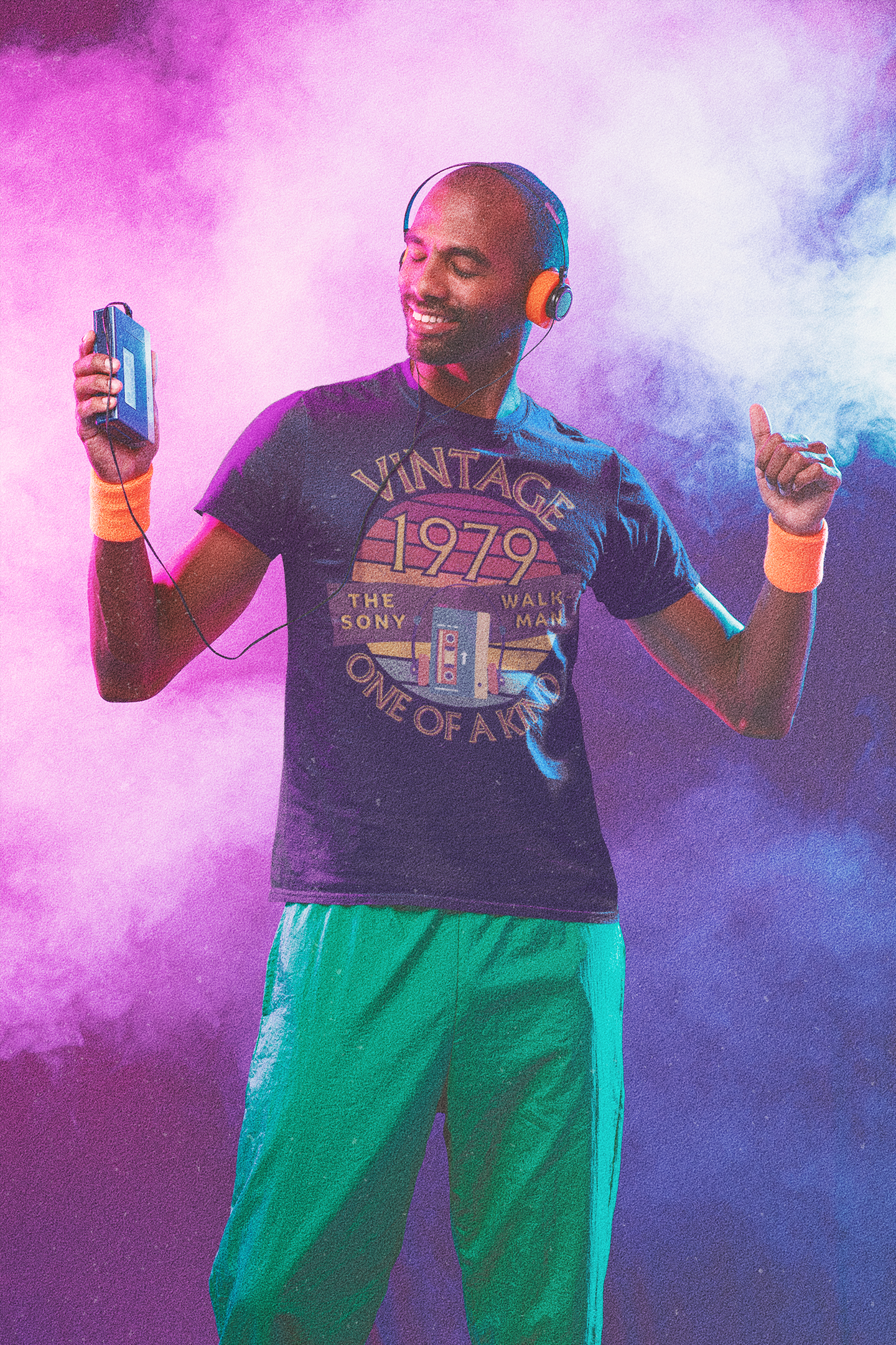 A man wearing black T-Shirt dancing with words vintage,1979,the sony walkman,one of a kind, image of the original TPS-L2 model in front of a brown distressed sunset
