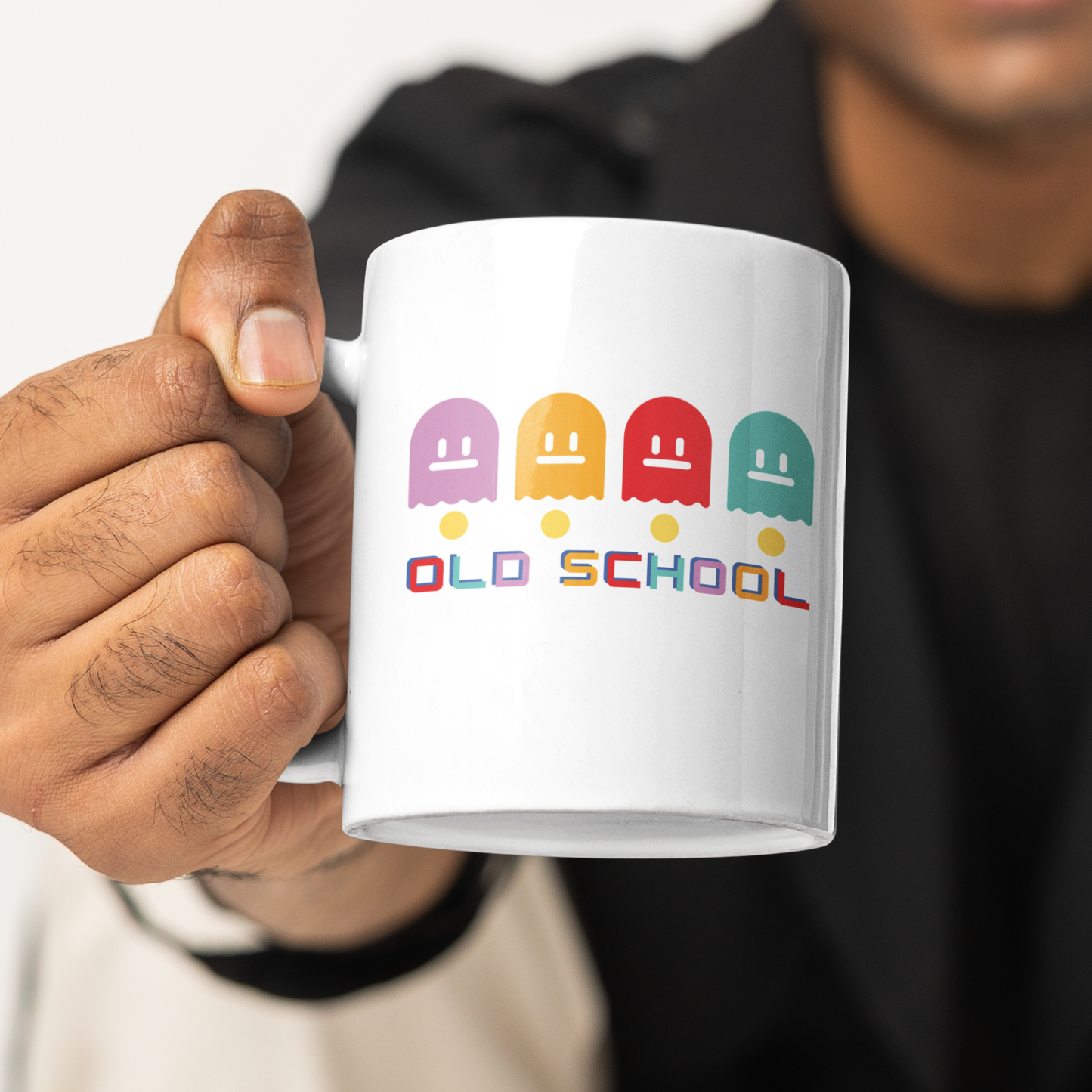 White mug with multicoloured ghost characters , over yellow pac man dots and old school in different colours for each letter  