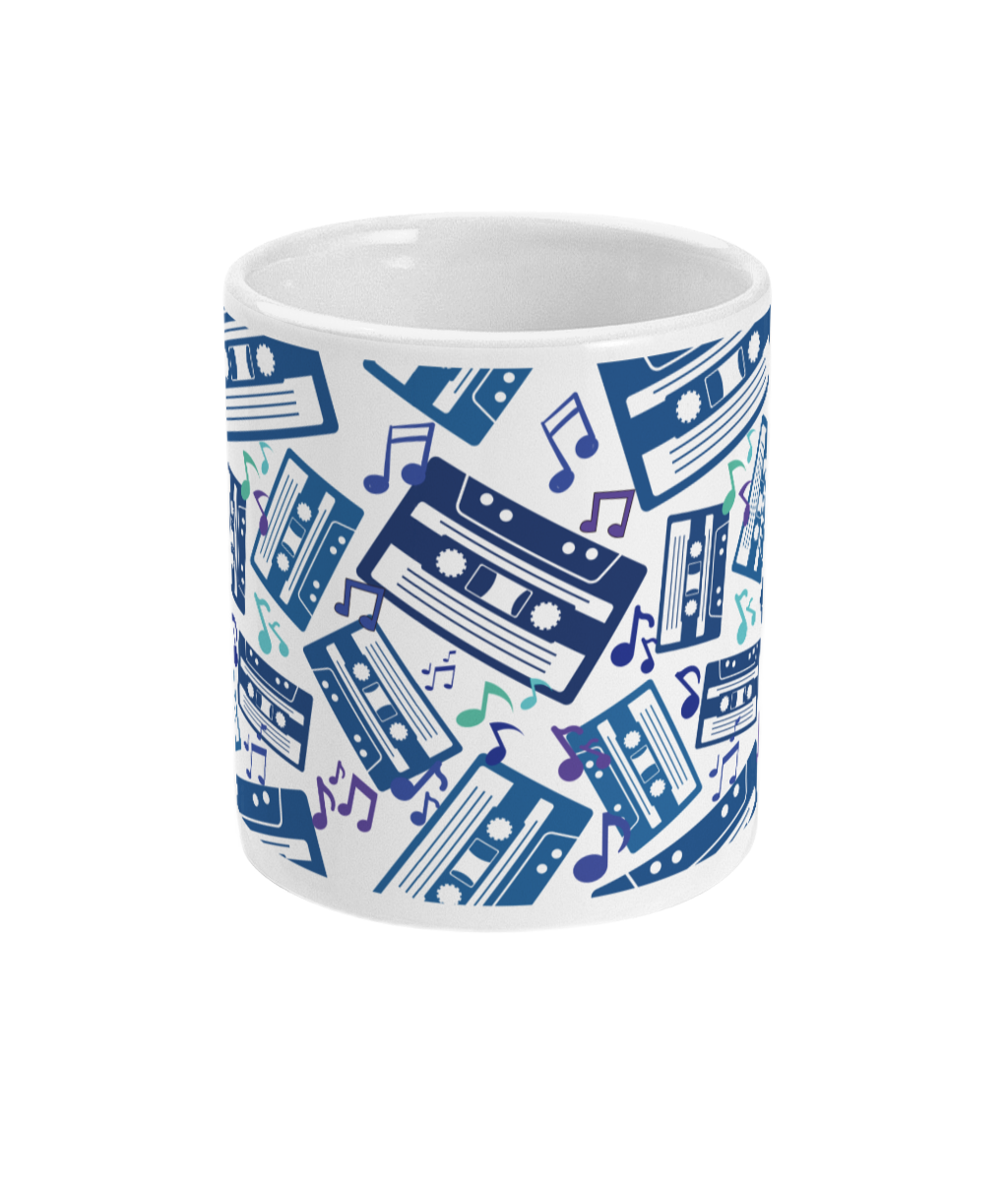 White mug with blue toned and purple music notes and cassette tapes spread out at different angles in different shades of blue around the sides and front.