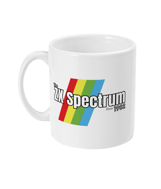 White mug featuring a retro design with the text " ZX Spectrum”  and text  “Since1982" in white with a black border  . Diagonal rainbow stripes in red, yellow, green, and blue run behind and evoke the iconic Sinclair ZX Spectrum branding.