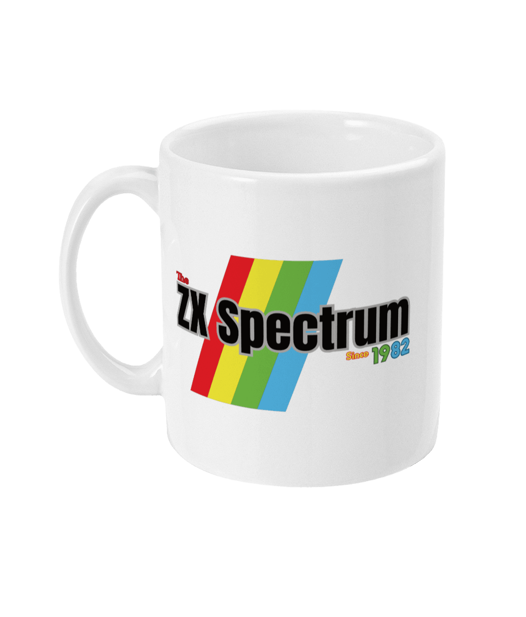 White mug featuring a retro design with the text " ZX Spectrum” in Black and  the text “Since1982" in, red, green, and blue lettering. Diagonal rainbow stripes in red, yellow, green, and blue run behind and evoke the iconic Sinclair ZX Spectrum branding.