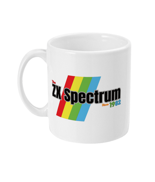 White mug featuring a retro design with the text " ZX Spectrum” in Black and  the text “Since1982" in, red, green, and blue lettering. Diagonal rainbow stripes in red, yellow, green, and blue run behind and evoke the iconic Sinclair ZX Spectrum branding.