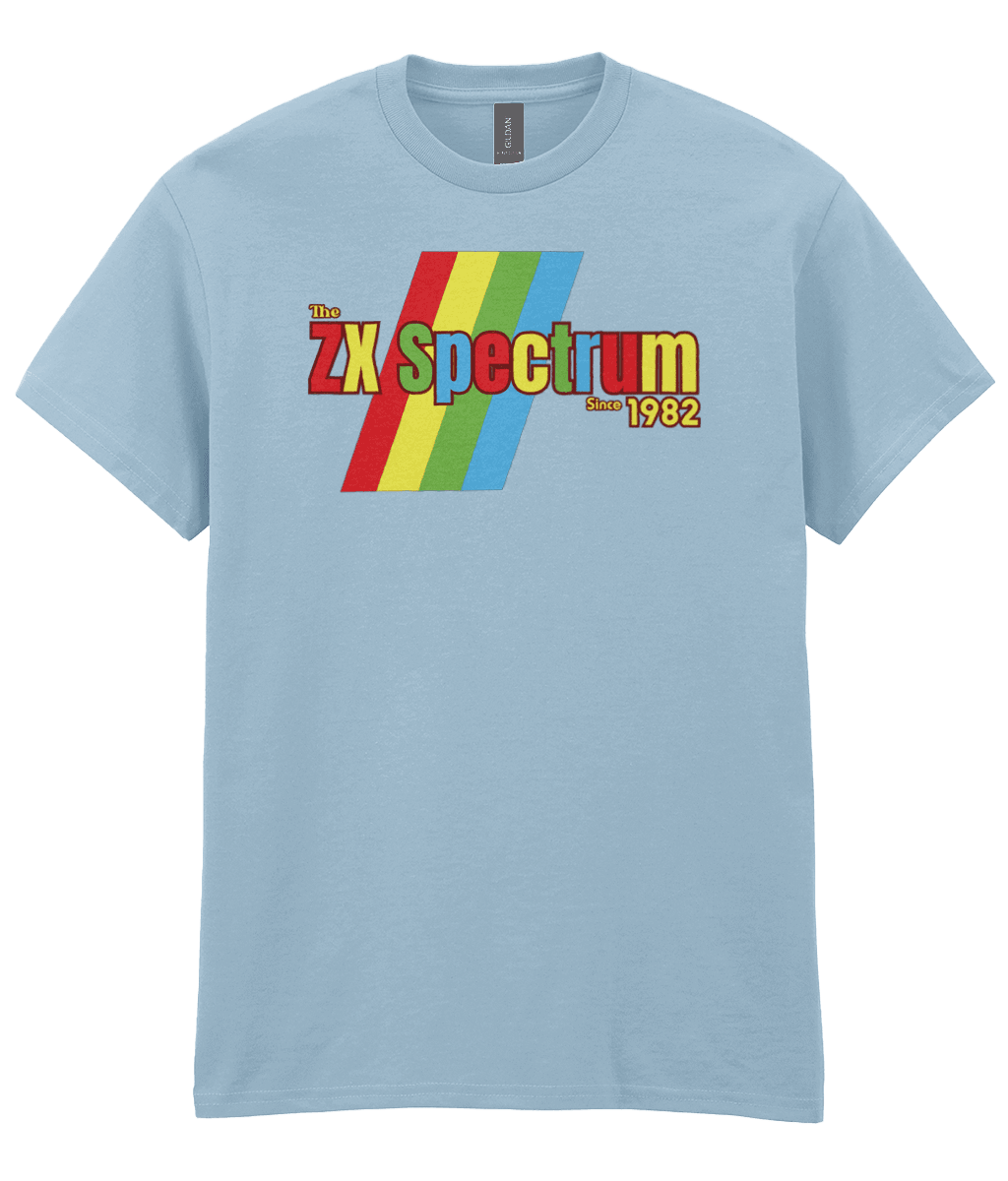 Light Blue T-shirt featuring a retro design with the text "The ZX Spectrum" in bold, stylized font. The word "Spectrum" appears in a red-to-yellow gradient, with "Since 1982" in small yellow text below. Four diagonal rainbow stripes—red, yellow, blue, and light blue—run behind the text, referencing the iconic Sinclair ZX Spectrum branding. The shirt pays homage to the 1982 British home computer that sparked playground rivalries and a generation of 8-bit creativity.
