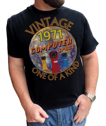 A man wearing black T-Shirt with the words vintage,1971,computer space,one of a kind,large earth, 3 computer space arcade machines