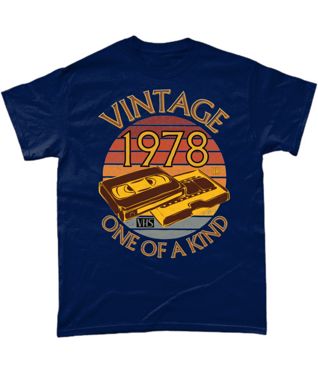 Navy T-Shirt with words vintage,1978,uk,one of a kind, image of a simple VHS tape in front of a brown distressed sunset