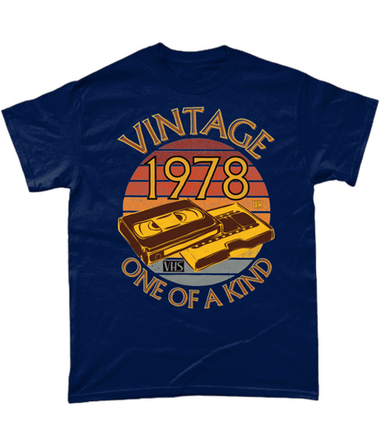 Navy T-Shirt with words vintage,1978,uk,one of a kind, image of a simple VHS tape in front of a brown distressed sunset