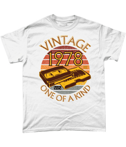 White T-Shirt with words vintage,1978,uk,one of a kind, image of a simple VHS tape in front of a brown distressed sunset