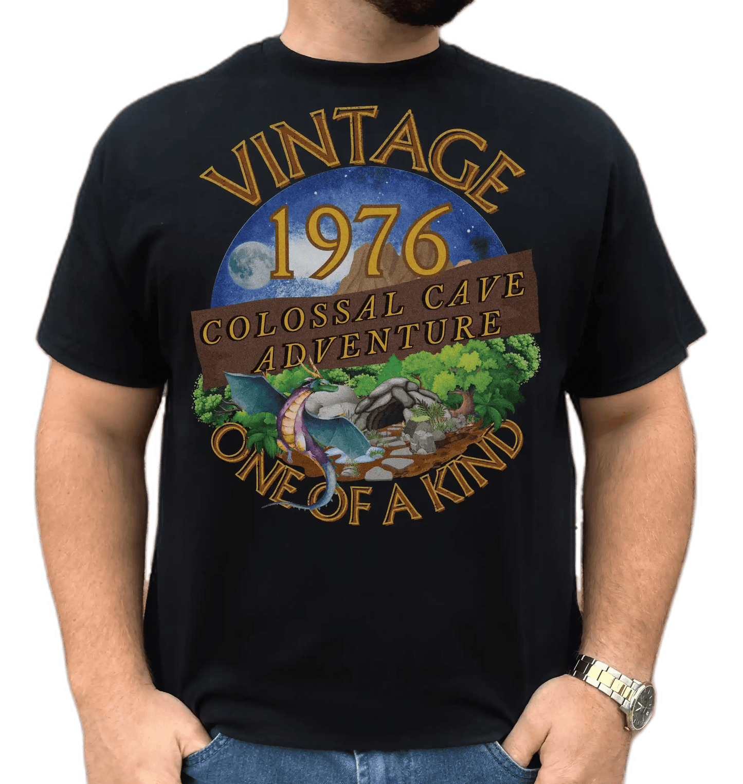 A man wearing a black T-Shirt with words vintage,1976,colossal cave adventure,one of a kind,circular picture of a dragon,cave and woodland,night sky